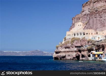 Ancient building in the port of Fira, the capital of Santorini island, Greece. Cliff on the Aegean sea
