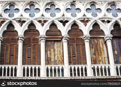 Ancient building in Venice, Italy. Worn and grungy facade with columns and stained glass windows