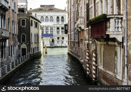 Ancient buildings and boats in the channel in Venice.