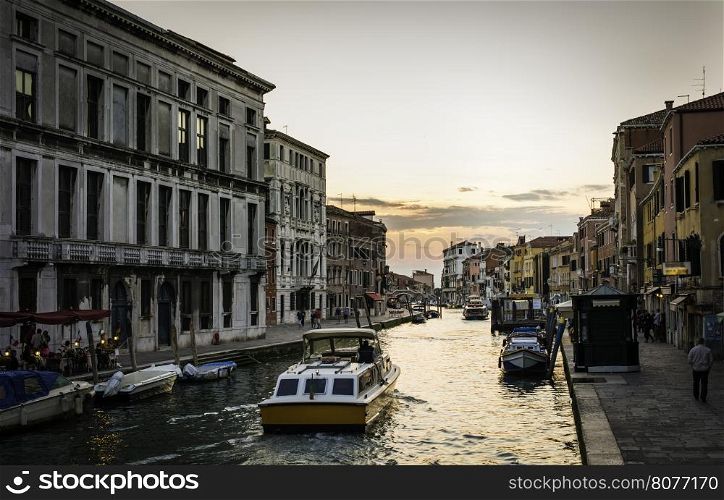 Ancient buildings and boats in the channel in Venice.