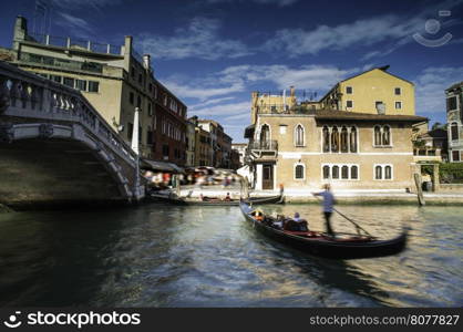 Ancient buildings and boats in the channel in Venice.