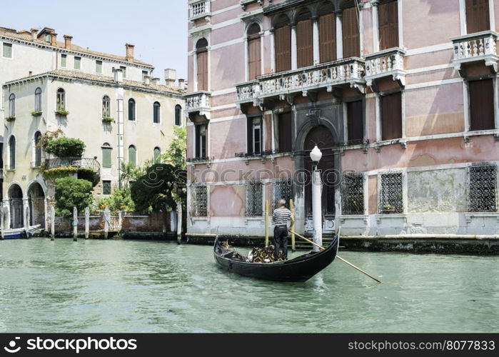 Ancient buildings and boats in the channel in Venice.