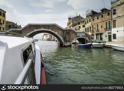 Ancient buildings and boats in the channel in Venice.