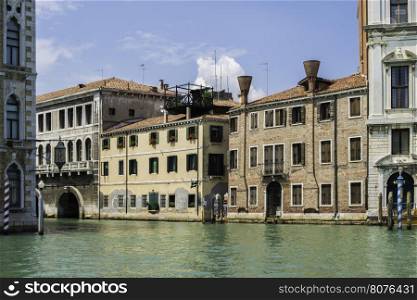 Ancient buildings in Venice. Boats moored in the channel. View from the side of the water