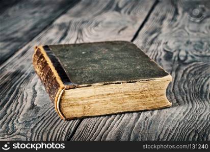 Ancient closed book with green cover on a wooden table. Ancient closed book with green cover