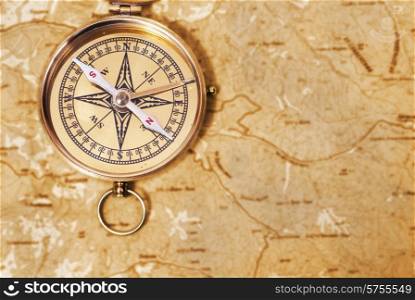 Ancient compass on the grunge old map