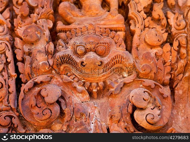 Ancient daemon carving on the wall in temple Banteay Srei, Cambodia