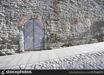 Ancient door by cobblestone street; Tallinn; Estonia; Europe