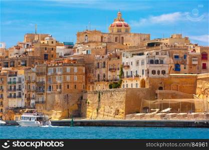 Ancient fortifications of Valletta, Malta.. Quay of Valletta with traditional Maltese building with colorful shutters and balconies in the sunny day, Valletta, Capital city of Malta