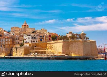 Ancient fortifications of Valletta, Malta.. Quay of Valletta with traditional Maltese building with colorful shutters and balconies in the sunny day, Valletta, Capital city of Malta
