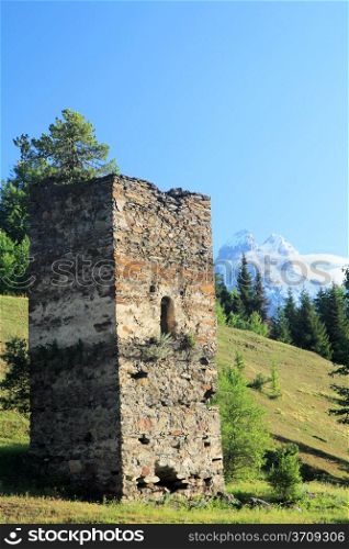 Ancient Georgian tower on hills and blue sky background. Svanetia