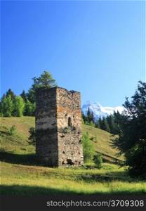 Ancient Georgian tower on hills and blue sky background. Svanetia