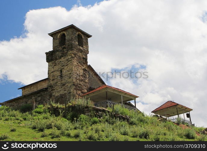 Ancient Georgian tower on hills and blue sky background. Svanetia