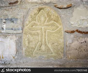 Ancient greek cross on the stone wall. Background