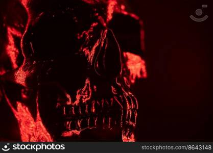 Ancient human skull head close-up. Neon red light. Spooky and sinister. Glamour, disco, halloween concept.. Ancient human skull head close-up. Neon red light. Spooky and sinister. Glamour, disco, halloween concept