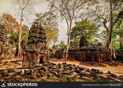 Ancient Khmer architecture. Panorama view of Ta Prohm temple with giant banyan trees at Angkor Wat complex, Siem Reap, Cambodia. Image in vintage style