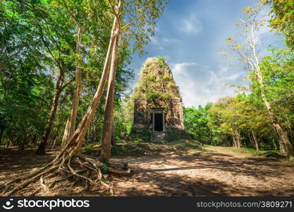 Ancient Khmer pre Angkor architecture. Sambor Prei Kuk temple ruins with giant banyan trees under blue sky. Kampong Thom, Cambodia travel destinations