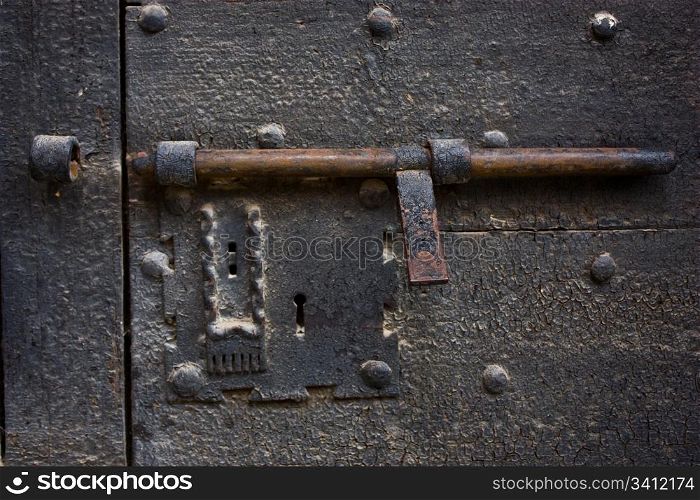 Ancient lock made of metal on a medieval door