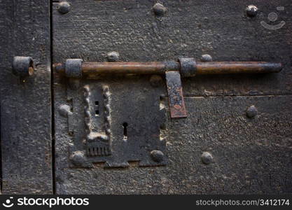 Ancient lock made of metal on a medieval door