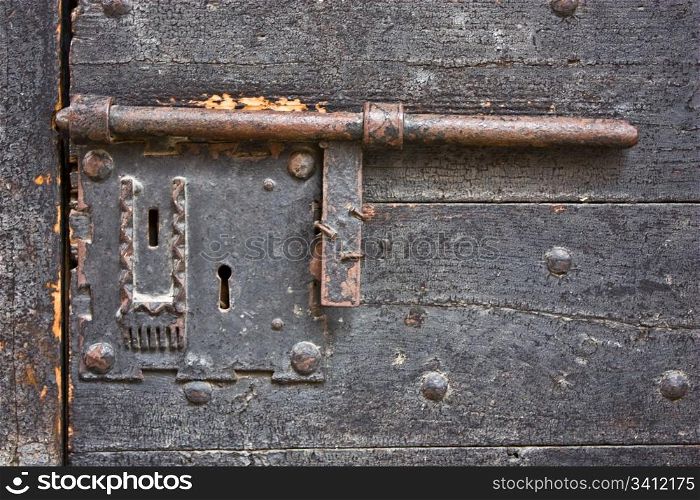 Ancient lock made of metal on a medieval door