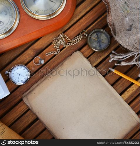 ancient mariner&rsquo;s compass, watch and old paper on wooden background