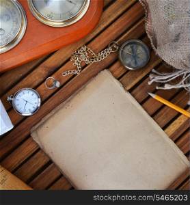 ancient mariner&rsquo;s compass, watch and old paper on wooden background