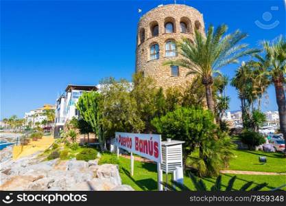 Ancient medieval tower at the entrance to the famous marina of Puerto Banus, Malaga, Spain