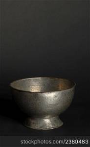 ancient metal bowl on dark background. antique bronze tableware. ancient metal utensils
