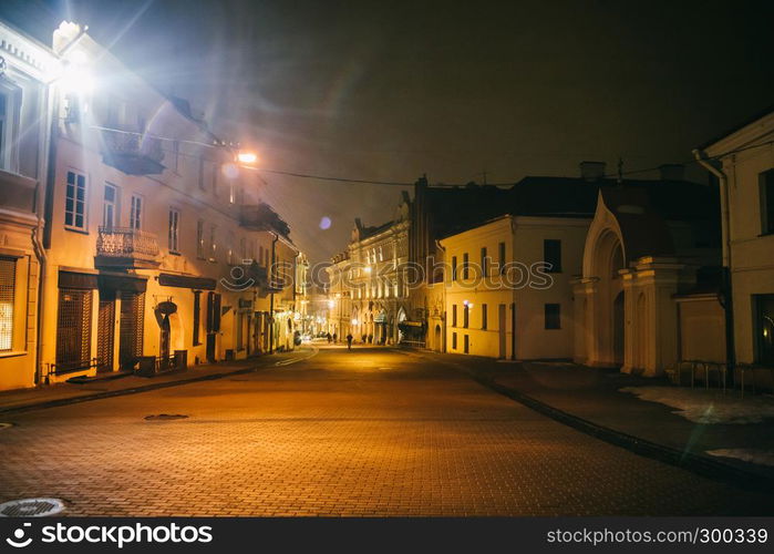 Ancient narrow night Vilnius street with old architecture and winter background