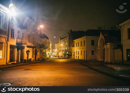 Ancient narrow night Vilnius street with old architecture and winter background