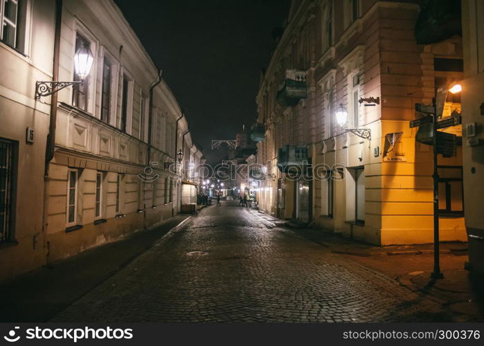 Ancient narrow night Vilnius street with old architecture and winter background