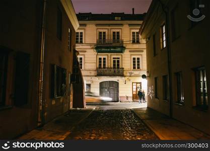 Ancient narrow night Vilnius street with old architecture and winter background