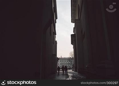 Ancient narrow Vilnius street with dark people silhoettes
