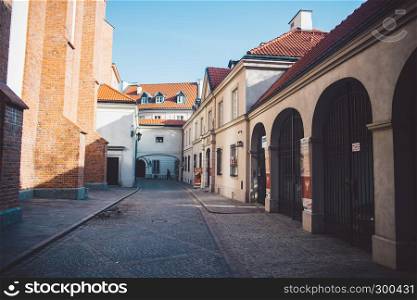 Ancient narrow Warsaw street with old architecture and winter background