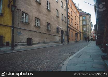 Ancient narrow Warsaw street with old architecture and winter background