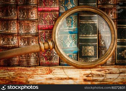 Ancient old books and magnifying glass