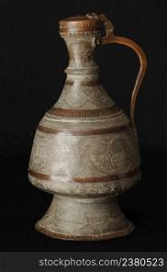 ancient oriental metal jug on dark background. antique bronze tableware. ancient metal utensils