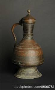 ancient oriental metal jug on dark background. antique bronze tableware. ancient metal utensils