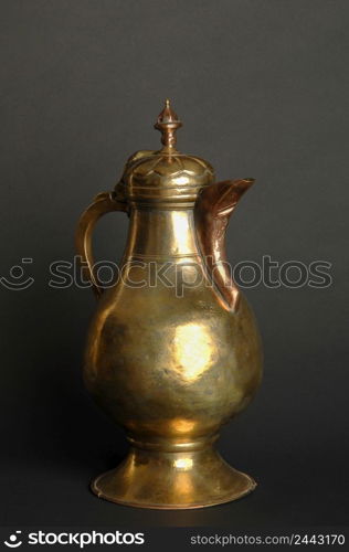 ancient oriental metal teapot on dark background. antique bronze tableware. ancient metal utensils