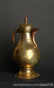 ancient oriental metal teapot on dark background. antique bronze tableware. ancient metal utensils