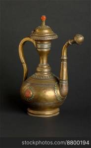ancient oriental metal teapot on dark background. antique bronze tableware. ancient metal utensils