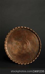 ancient oriental metal tray on dark background. antique bronze tableware. tray with engraving