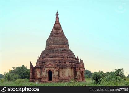 Ancient pagoda in the landscape from Bagan in Myanmar at sunrise