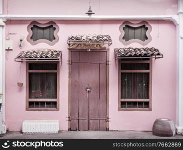 Ancient, pink building with a wooden, heavy door