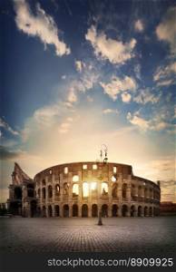 Ancient roman colosseum and sunny sunrise in Rome, Italy