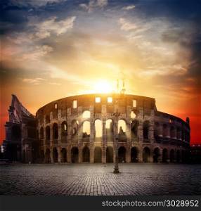 Ancient roman colosseum and sunny sunrise in Rome, Italy. Colosseum and sunny sunrise. Colosseum and sunny sunrise