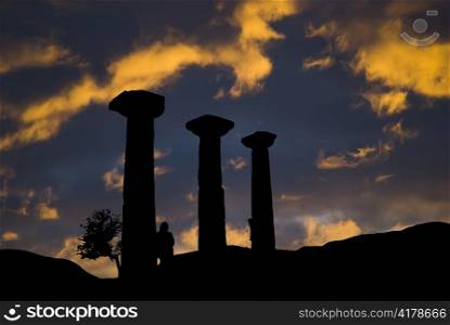 ancient ruins at sunset with lonely woman silhouette