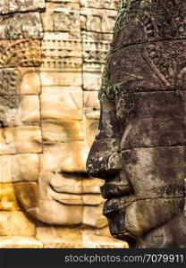 Ancient smiling stone face at Bayon Temple in Siem Reap, Cambodia