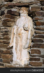 Ancient statue of an old man in the niche in the brick wall in Turkey