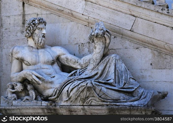 Ancient statue of the Tiber river god in front of the Senatorial Palace staircase on the Capitoline Hill in Rome, Italy